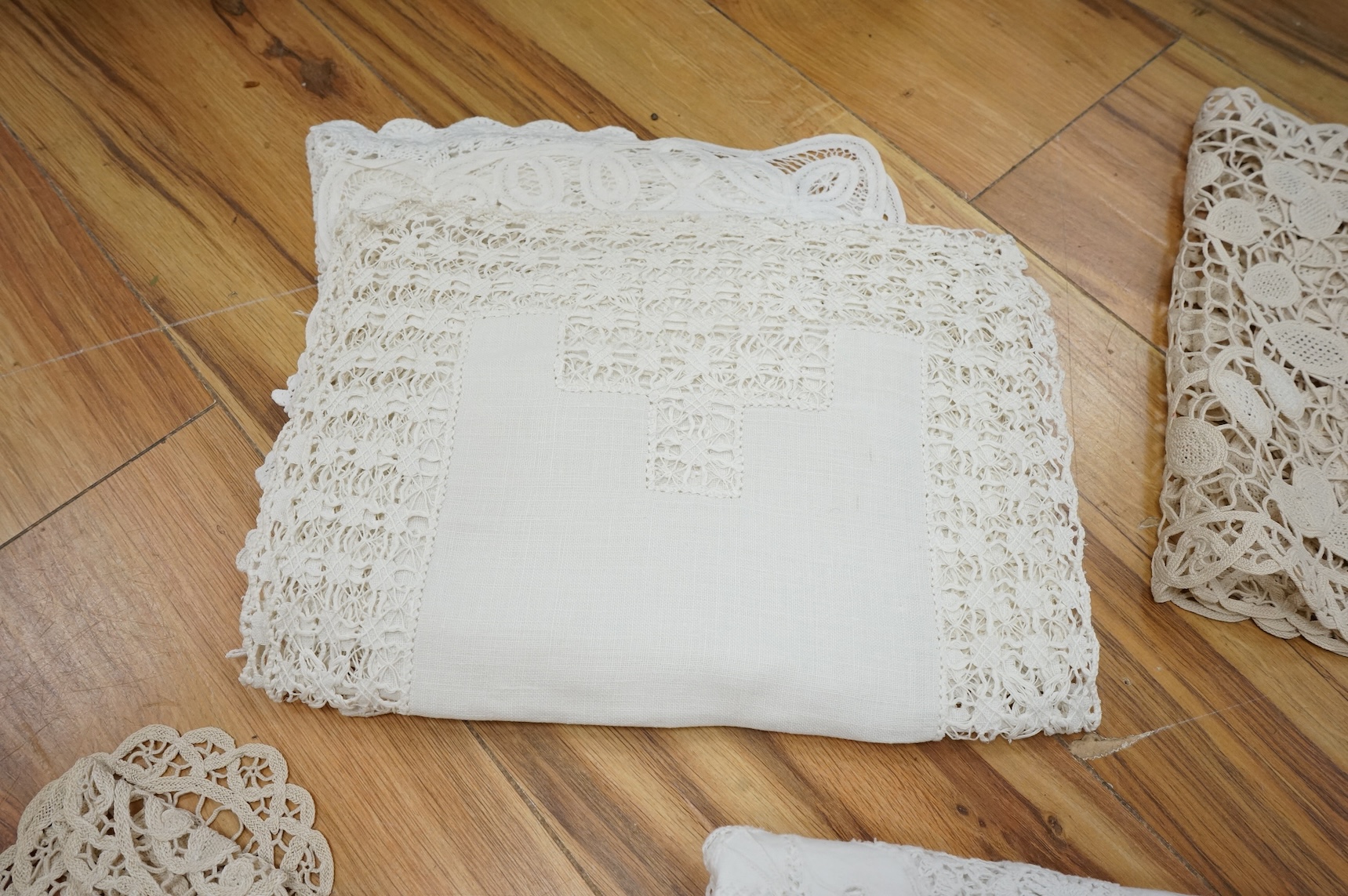 A collection of early 20th century and later crochet, cut work and drawn thread table linens and a large embroidered table cloth